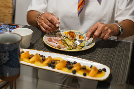 Detail of healthy breakfast with hands of woman in kitchenの写真素材