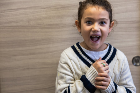 Portrait of a little girl posing on camera with surprised expression, white spaceの写真素材