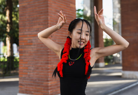 Closeup of smiling asian girl with hair ornaments dancing in the streetの写真素材