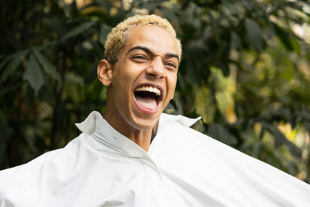 Portrait of modern black boy smiling with big white shirt, white spaceの写真素材