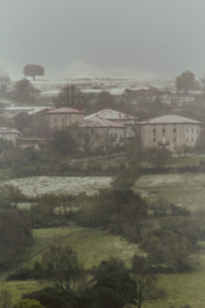 Vertical landscape of a small snowy rural village with fog and mistの写真素材