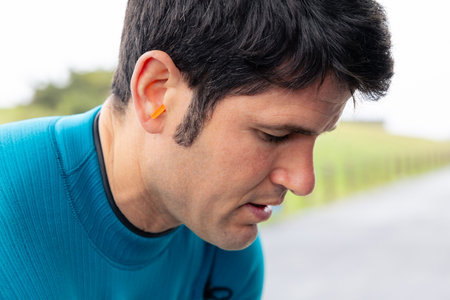 Portrait of a surfer with earplugs fitted for ocean protection.