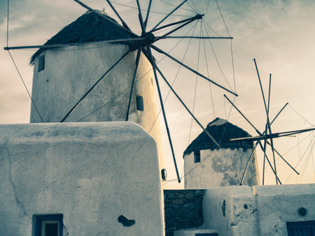 The iconic silhouette of Santorini's windmills stands against the dusky sky, a testament to the...
