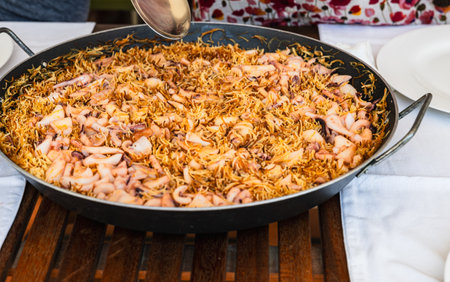 A large pan of traditional seafood noodle is presented on a wooden dining table.の写真素材