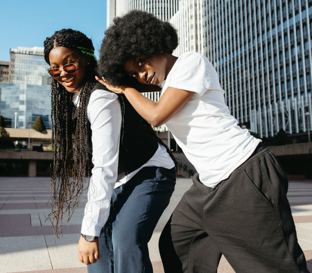 Afro women supporting each other and looking at camera in the cityの写真素材