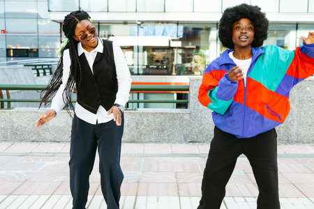 Happy Afro women dancing in urban street on a festive dayの写真素材