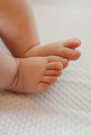 Tiny baby feet resting on soft fabric with copy space