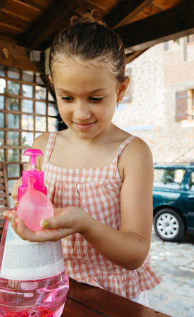 Seven-year-old girl concentrating while filling a water balloonの写真素材