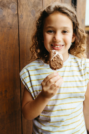 Happy girl with chocolate ice cream smiling at cameraの写真素材