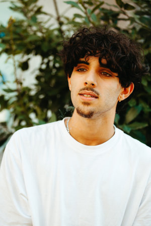 Young man in white shirt relaxing outdoorsの写真素材
