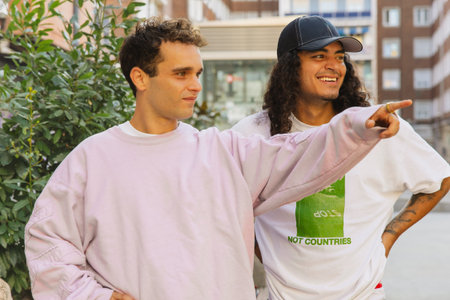 Two stylish skaters standing and smiling during a break in the city