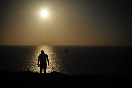 Man and boat in sunsetの写真素材