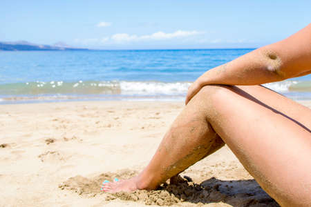 Woman legs on the beachの写真素材