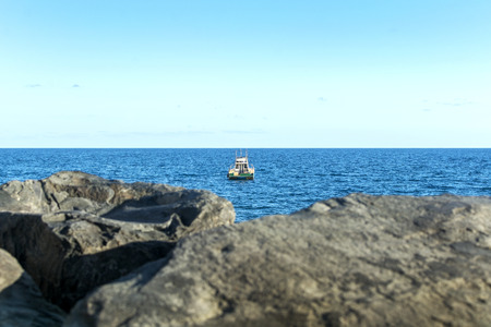 Boat in the distance, near the horizon.の写真素材