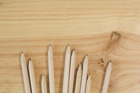 wooden pencils on wooden textured background. School or office material.の写真素材