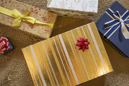 Gold and blue Christmas gift boxes with red pompom.