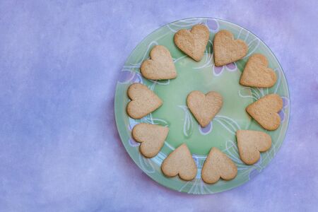Beautiful vintage plate with heart-shaped cookies isolated on bluish background.の写真素材