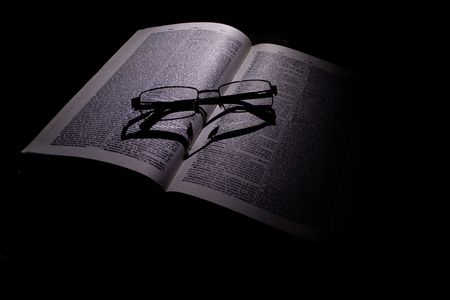 pen book and glasses placed on a black backgroundの写真素材
