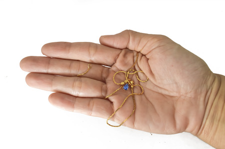 Female hand presenting gold jewelry isolated on whiteの写真素材