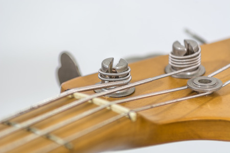 the head of an electric bass with details of the sprocket, the string guide,