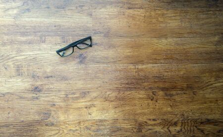 black nerdy glasses on a wood floorの写真素材