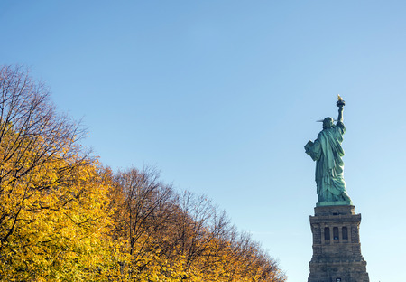 back of the statue of liberty with autumn foliageの写真素材