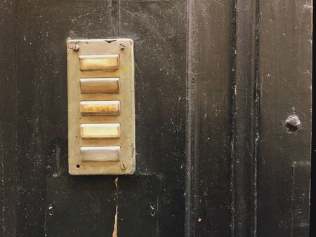 Old interphone in an ancient wooden doorの写真素材
