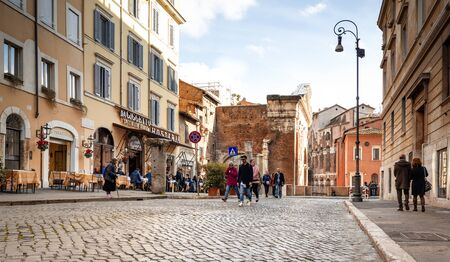 Rome, Italy, february 11, 2017: outdoor scene with people walking along the cobblestone streets of the ancient roman jewish Quarter with the Portico of Octavia, The Theatre of Marcellus and the historical restaurant Giggetto in the backgroundのeditorial素材