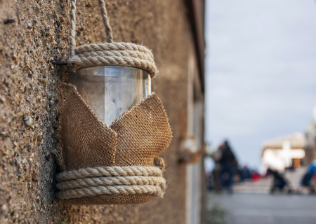 Vintage Candle glass lantern with rope hanging outdoorの写真素材