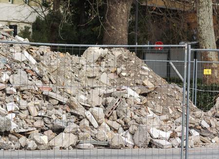 a pile of debris on a construction site behind a blurred fence