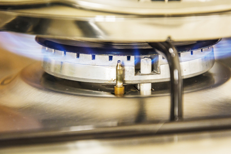 Focus of blue flame gas on a cooker boiling pot in kitchen gas stove. Cooking Food.の写真素材