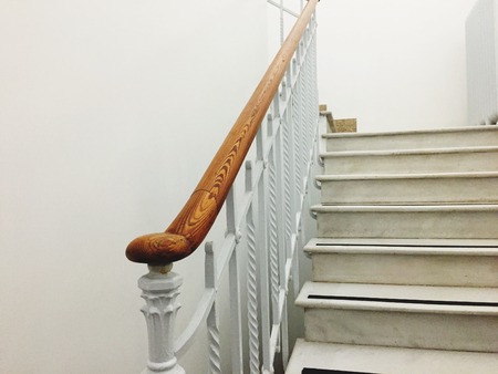 Ancient white staircase with elegant wooden handrail