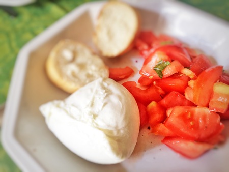 Fresh Italian caprese salad with mozzarella cheese, tomatoes and bread. Summer food