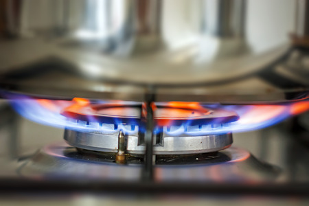 Blue glowing flame burning from the kitchen cooker. Gas and fire. Cooking concept. Interior domestic shotの写真素材
