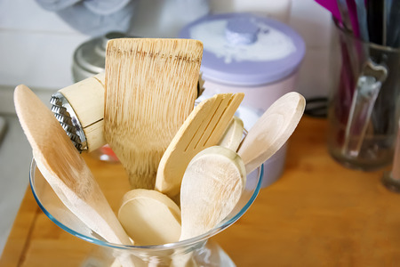 Wooden kitchen utensils in a glass container. Kitchen interior shot. Home decor and cooking conceptの写真素材