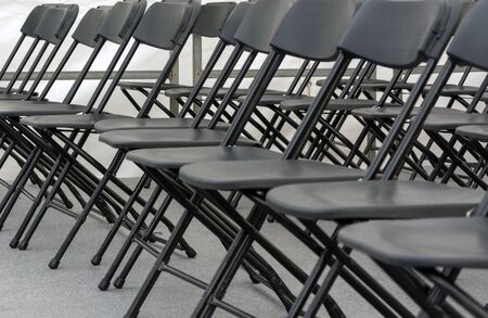 numerous folding chairs arranged in a row in a conference room.の写真素材