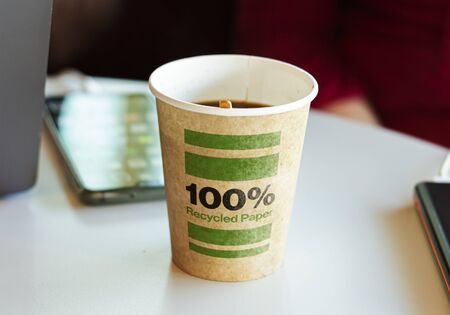a recycled paper container containing hot coffee for a break. Environmental protection and...