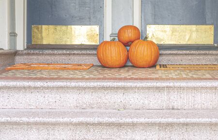 three pumpkins at the end of a staircase of a residential house. Halloween decorations