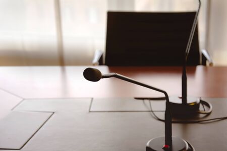microphone on a wooden table and an empty chair in a boardroom. Business conceptの写真素材
