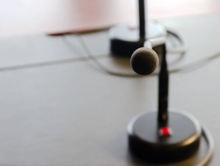 a table microphone on the wooden table of a board. Business and finance. Public speechの写真素材