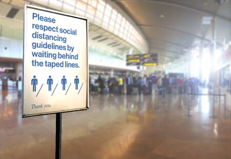 a sign inside an airport warns of the need to maintain the minimum safety distance between people to...