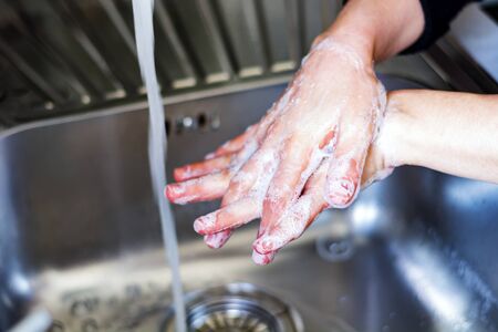 a young caucasian woman washing her hands with soap. Coronavirus pandemic COVID-19. Keeping hands...
