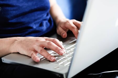 young caucasian woman typing on laptop keyboard. Working from home. Smart working concept