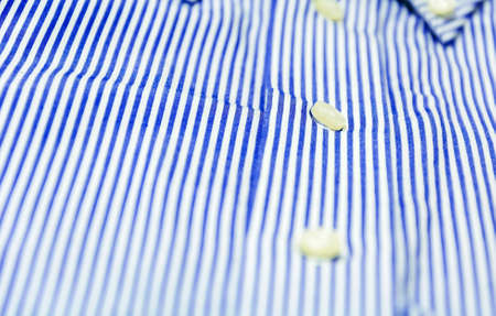 The button of a blue striped shirt with a button down collar. Formal wear for events or work and business meetingsの写真素材