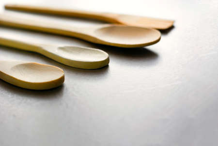 Group of wooden kitchen spoons arranged on a gray marble table. Kitchen utensils and cooking. Wooden...