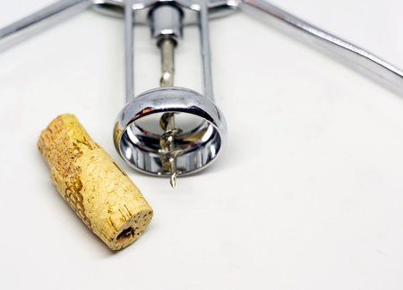steel wing corkscrew with a perforated cork isolated on a white background.
