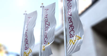 London, UK, February 26, 2021: Three vertical white flags with the Astrazeneca logo are flapping....