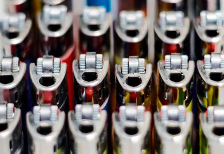Close-up view of a group of many plastic lighters arranged in rows. Selective focus. Smoking and accessories. Concept of teamwork and unityの写真素材