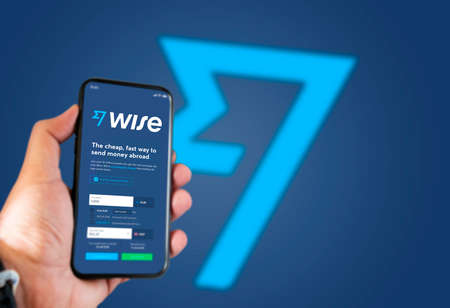 London, UK, May 2021: A hand holding a phone with the Wise app on the screen. Wise is a financial...
