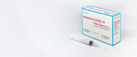 Cambridge, MA, USA, february 5th 2021: A syringe next to the ModeRNa Covid-19 vaccine box isolated on a white background. Health and prevention.のeditorial素材